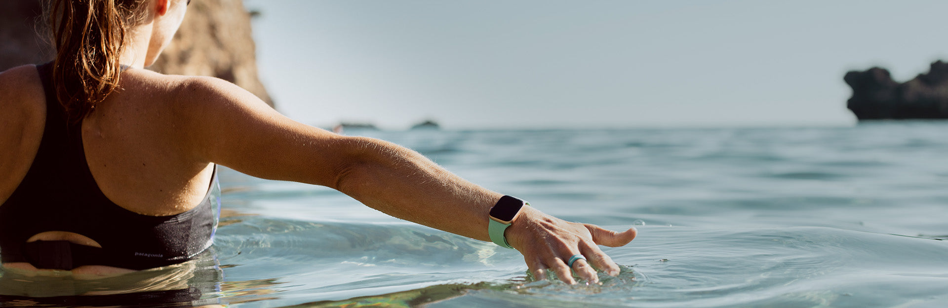 girl on vacation in the water featuring Groove Life Apple Watch band and stackable ring.