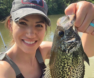 Jennifer Pudenz holds up a spotted fish to the camera